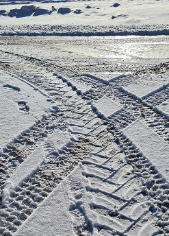 Vereiste, überschneite Fahrspuren, die sich überkreuzen.